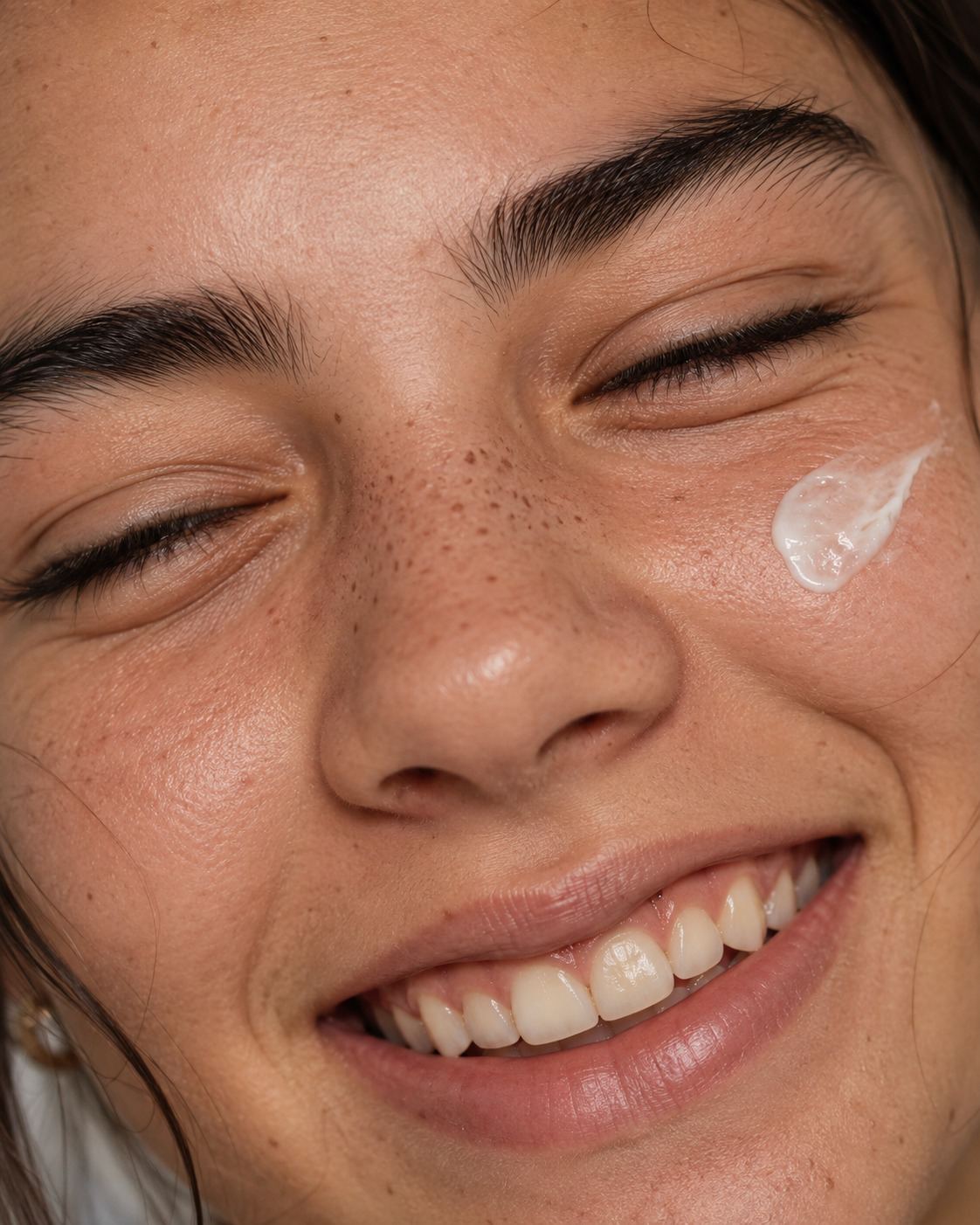 Primer plano de un rostro adolescente sonriendo con crema en la mejilla